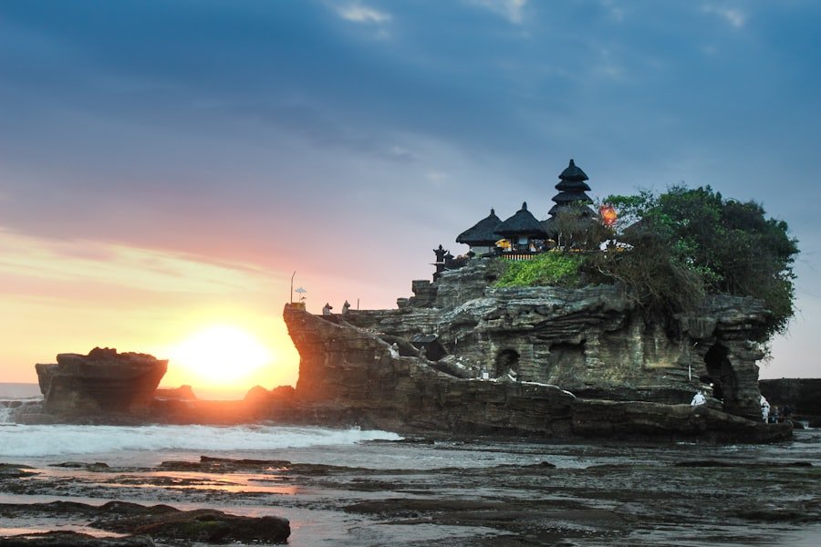 Pura Tanah Lot rising from its rock offshore on Bali's west coast as the sun sets behind it.